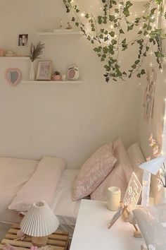 a bedroom with white walls and lots of plants hanging from the ceiling over the bed