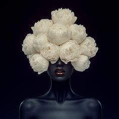 a black mannequin head with white flowers on it's head, against a dark background