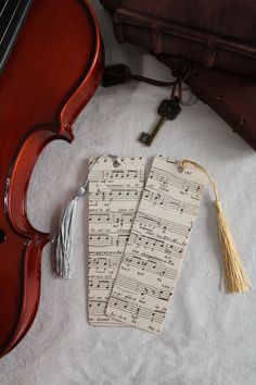 two tags with music notes on them next to a violin