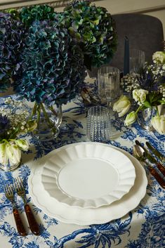 the table is set with blue and white flowers