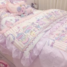 there is a pink bed with unicorns on it and a stuffed animal in the middle