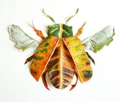 a bug made out of leaves on a white surface with green and orange colors in the back