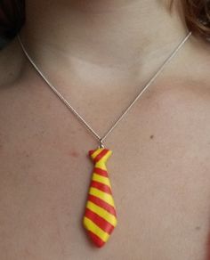 a woman wearing a yellow and red striped tie necklace