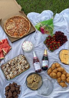 an assortment of food is laid out on a blanket