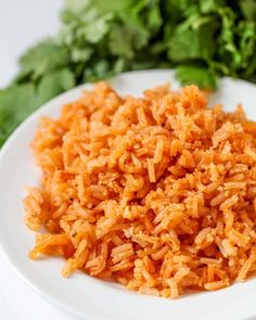 a white plate topped with rice next to some parsley on top of a table