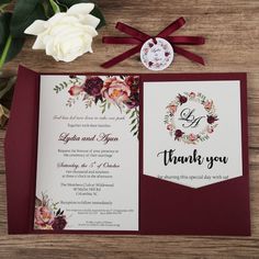 the wedding stationery is laid out on a table with flowers and ribbon around it