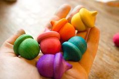 a person's hand holding small colorful toy birds