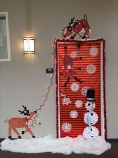 a snowman is standing in front of a door decorated with christmas lights and decorations