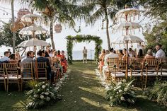 an outdoor ceremony with chairs and umbrellas