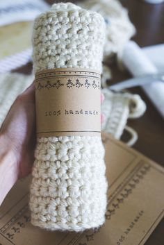 a hand holding a crocheted bottle with a label that says 100 % handmade