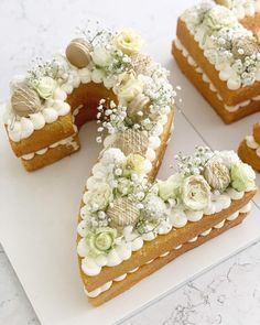 there are four pieces of cake on the white plate with flowers and pearls around it