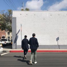 two men walking down the street holding hands