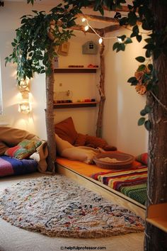 a room that has a tree in the corner and some pillows on the floor next to it