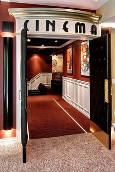 an open door leading to a movie room with red carpeting and white trimming