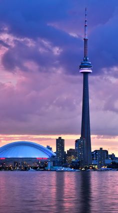 the sky is pink and purple as the sun sets over the cityscape in the background