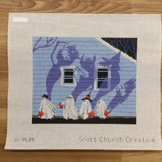 a cross stitch picture with three ghost on it