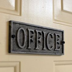 an office sign mounted to the side of a door that says office on it's metal frame