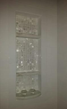 a window in the corner of a white tiled bathroom with glass blocks on it's wall