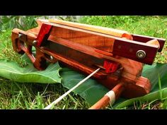 a wooden bench sitting on top of a green leaf covered ground next to a plant