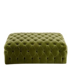 a green velvet bench with buttons on the top and bottom, in front of a white background