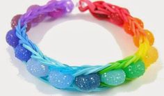 four different colored bracelets on a white surface