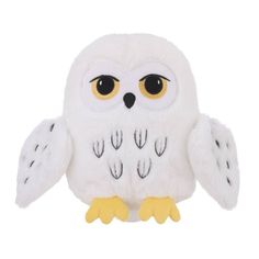 a white stuffed owl with yellow feet and big eyes is sitting on a white surface