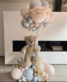 a teddy bear sitting on top of balloons