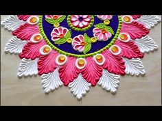 an intricately decorated wall hanging with flowers and leaves in pink, blue, green and white colors