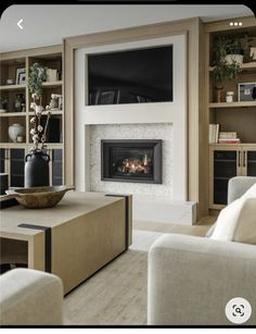 a living room filled with furniture and a flat screen tv mounted on the wall above a fire place