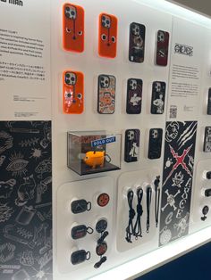 a display case filled with lots of different cell phone cases and magnets on the wall