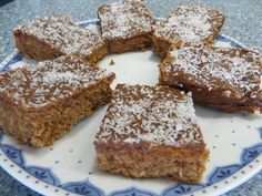 several pieces of dessert on a plate with powdered sugar