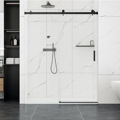 a bathroom with black and white tile flooring and walls, along with a walk in shower