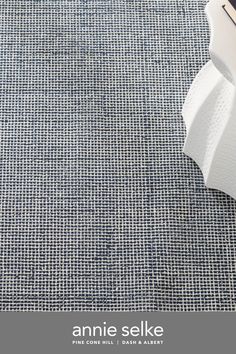 an area rug with a blue and white checkered pattern on the floor, next to a computer keyboard