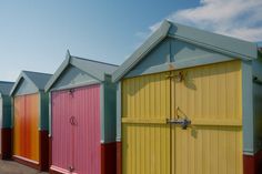 a row of colorful beach huts sitting next to each other