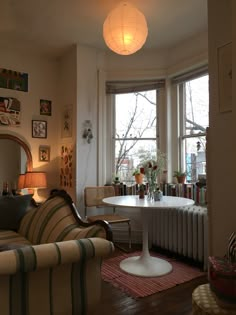 a living room filled with furniture and a round table in front of a large window