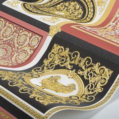 an intricately designed table cloth with gold and black designs on it's edges