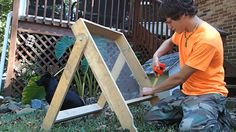 a young man working on an outdoor bird feeder