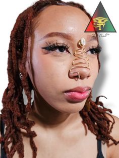 a woman with dreadlocks has a nose piece in her mouth and is wearing a fake nose ring