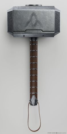 an old hammer with a metal handle on it's head and a leather cord attached to the handle