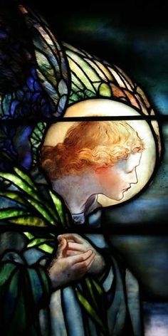 a close up of a stained glass window with a woman