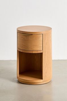 a round wooden table with a drawer on the bottom and one shelf in the middle