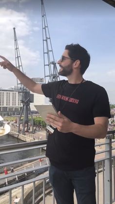 a man points at something while standing on a balcony