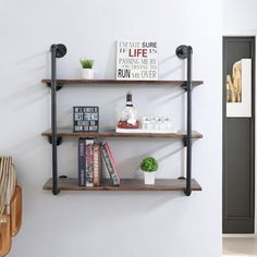 three shelves with books and plants on them