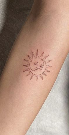 a small sun and moon tattoo on the arm