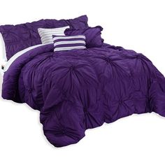 a bed with purple comforter and pillows on it