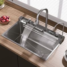 a stainless steel sink with water running from the faucet and some fruit on the counter