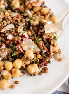 a white plate topped with lentils and radishes