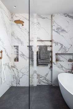 a white bath tub sitting next to a walk in shower