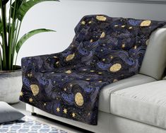 a couch with a blue and gold pattern on it next to a potted plant