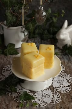 three pieces of cake on a white plate with greenery in the backgroud